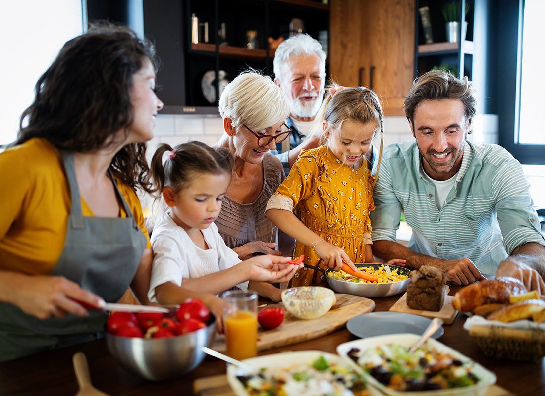 Personal Insurance - Cheerful Family Spending Good Time Together While Cooking in the Kitchen